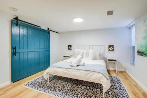 a bedroom with a large bed with a blue door at SUNNY, SERENE & CENTRALLY-Located STUDIO *PRIVACY *COMFORT *5-STARS in Washington, D.C.