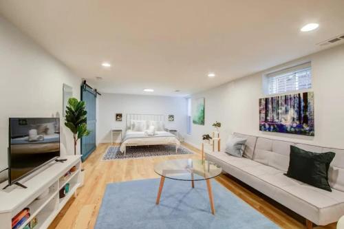 a living room with a white couch and a table at SUNNY, SERENE & CENTRALLY-Located STUDIO *PRIVACY *COMFORT *5-STARS in Washington, D.C.