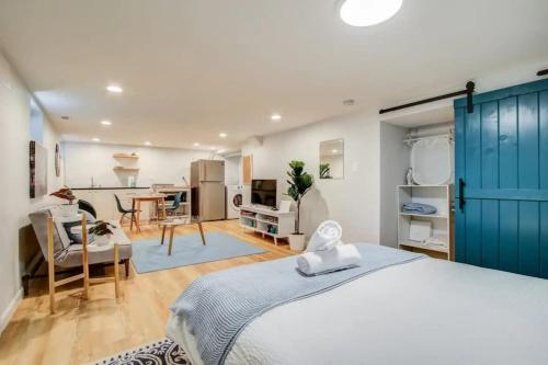 a bedroom with a blue door and a living room at SUNNY, SERENE & CENTRALLY-Located STUDIO *PRIVACY *COMFORT *5-STARS in Washington, D.C.
