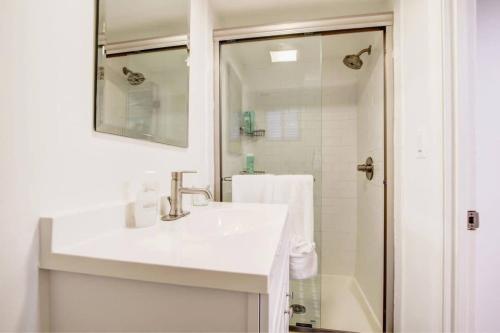 a white bathroom with a sink and a shower at SUNNY, SERENE & CENTRALLY-Located STUDIO *PRIVACY *COMFORT *5-STARS in Washington, D.C.