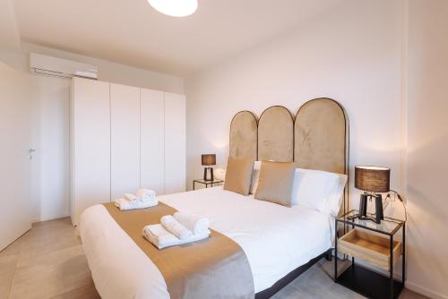1 dormitorio con 1 cama blanca grande y 2 toallas en Sea Sense Suite 8 en Bari
