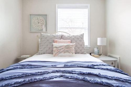 a bedroom with a bed with a blue blanket and a window at Transit-Friendly Home Old Town Parking in Alexandria