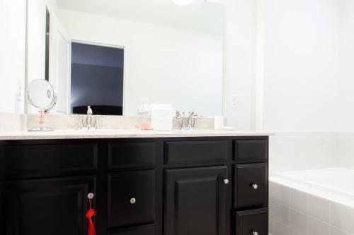 a bathroom with a sink and a mirror at Large MD Townhome mins to UMD & DC Parking in Greenbelt