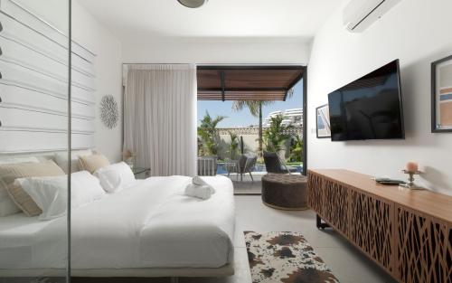 Habitación de hotel con cama, TV y sala de estar. en LUX amazing villa with private pool, en Eilat