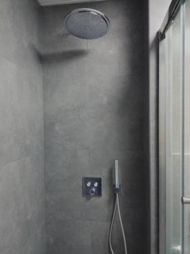 a bathroom with a shower with a light on the wall at Quite and Cozy in Seeb