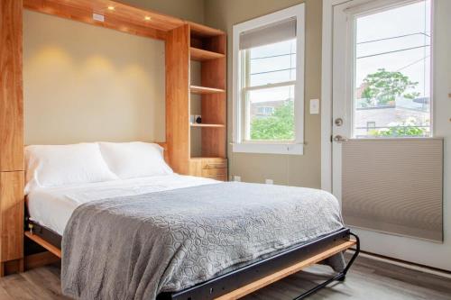 a bedroom with a bed and two windows at Eastern Market Carriage house efficiency PRIVACY in Washington, D.C.