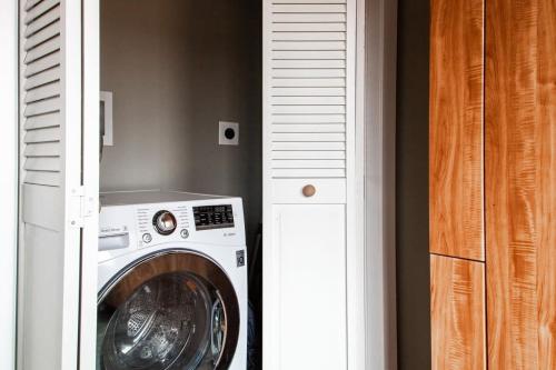 a washing machine in a room next to a door at Eastern Market Carriage house efficiency PRIVACY in Washington, D.C.