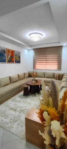ein Wohnzimmer mit einem Sofa und einem Tisch in der Unterkunft Appartement de Luxe sur Témara in Temara