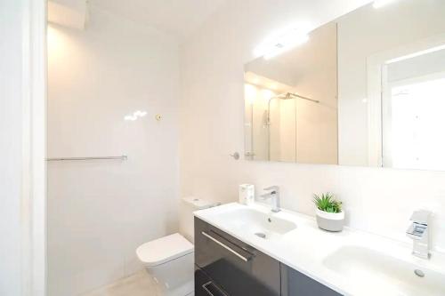a bathroom with a sink and a toilet and a mirror at PENTHOUSE BELLAVISTA with SEA VIEWS in Torrevieja