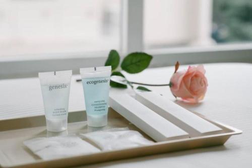 a tray with two bottles of sunscreen and a rose at Value Hotel Thomson in Singapore