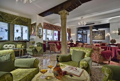 a living room with green couches and tables at Hotel Giorgione in Venice