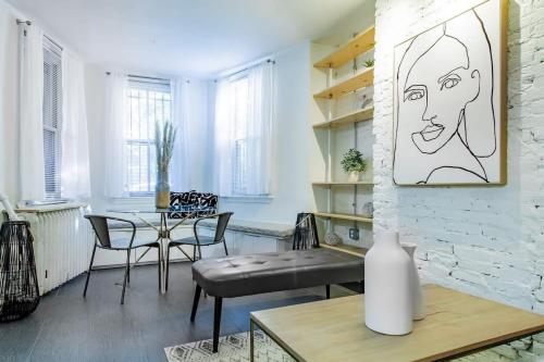 a living room with a table and chairs and a drawing on the wall at DesignerFlat Nestled Between Dupont&Logan Circles in Washington, D.C.