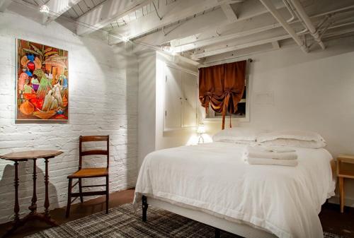 a bedroom with a white bed and a table and a painting at The E St Retreat Lovely 3-BR Nestled between H St & Eastern Market in Washington, D.C.