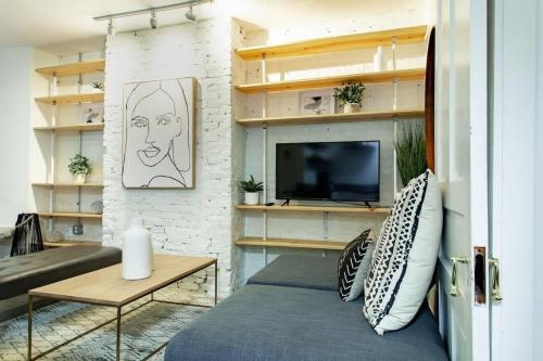 a living room with a bed and a tv at DesignerFlat Nestled Between Dupont&Logan Circles in Washington, D.C.