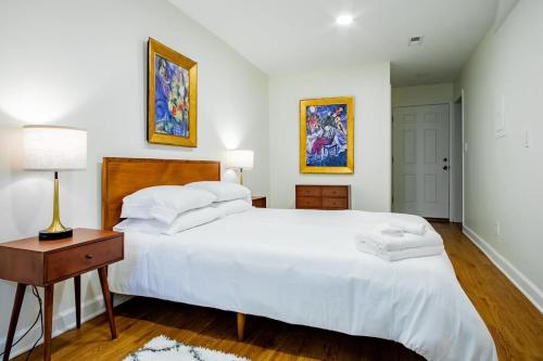 a bedroom with a large white bed and a table at A Classy Corner of DC Minutes walk to Dupont Circle in Washington, D.C.