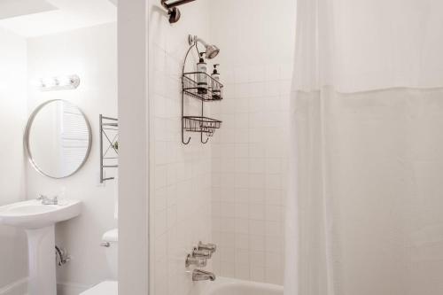 a white bathroom with a shower and a sink at Classy 1-BR Flat Nestled Between Dupont & Logan in Washington, D.C.