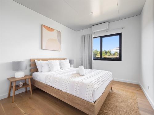 a white bedroom with a large bed and a window at Casa Burnside in Margaret River Town