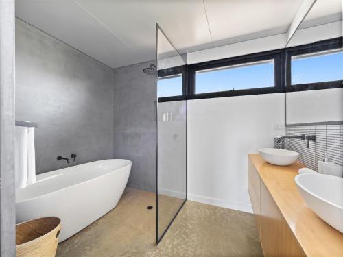 a bathroom with a bath tub and a sink at Casa Burnside in Margaret River Town