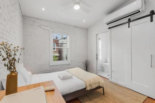 a white bedroom with a bed and a window at Adorable Studio Space in Private Carriage House in Washington, D.C.
