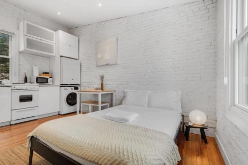 a bedroom with a bed and a white brick wall at Adorable Studio Space in Private Carriage House in Washington, D.C.