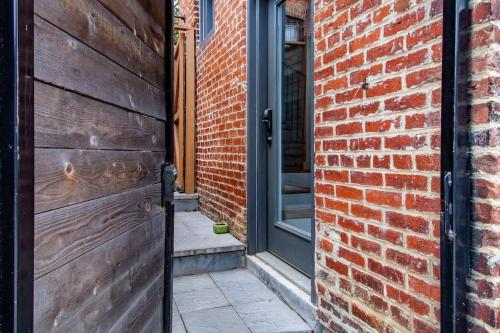 an entrance to a brick building with a wooden door at Adorable Studio Space in Private Carriage House in Washington, D.C.