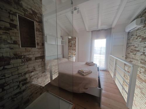 サンタンナ・アッレージにあるvilletta Fanny Porto Pinoのバスルーム(ガラス張りのシャワー、ベッド付)