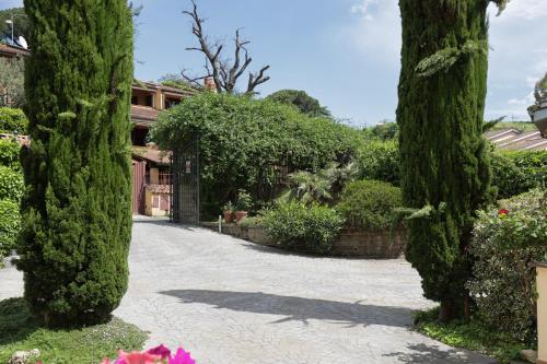 a driveway with trees and a building in the background at VILLA VEIO in Sacrofano