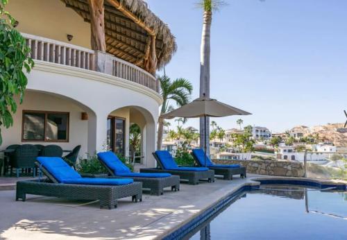 a patio with blue chairs and a swimming pool at Casa Tranquila San José del Cabo Villa Frente al Mar in San José del Cabo