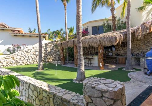 a resort with palm trees and a stone wall at Casa Tranquila San José del Cabo Villa Frente al Mar in San José del Cabo