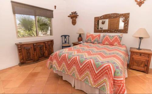 a bedroom with a large bed with a colorful comforter at Infinite views of Palmilla beach and East Cape in San José del Cabo