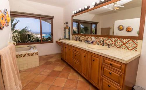 a bathroom with two sinks and a large mirror at Infinite views of Palmilla beach and East Cape in San José del Cabo