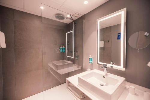 a bathroom with a sink and a mirror at Novotel Le Havre Centre Gare in Le Havre