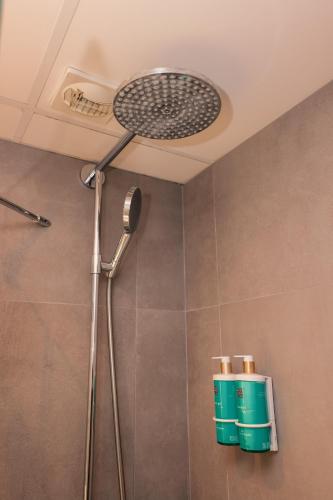 a shower with a shower head in a bathroom at Novotel Le Havre Centre Gare in Le Havre