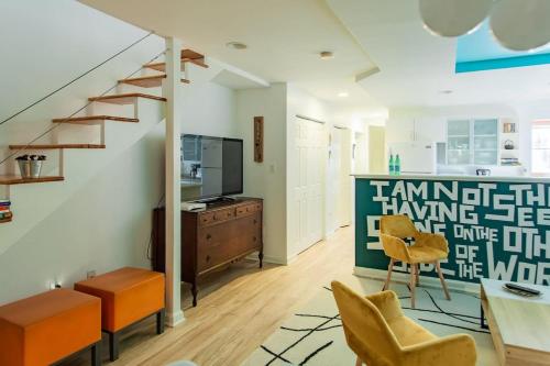 a living room with a staircase and orange chairs at Over the Moon About C Adams Morgan METRO subway Rock Creek Park in Washington
