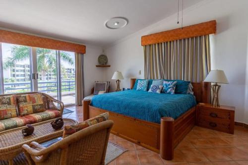 a bedroom with a bed and a couch at Villa Calafia Spacious Home w Private Tennis in Cabo San Lucas