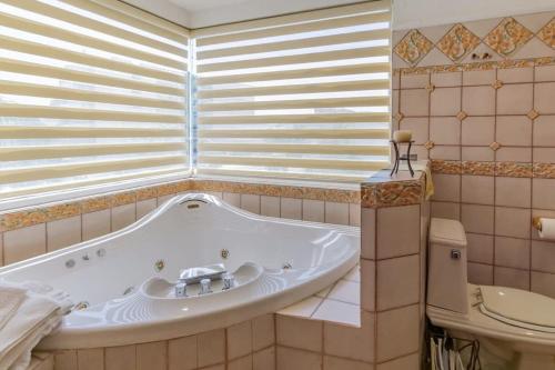 a bath tub in a bathroom with a toilet at Villa Calafia Spacious Home w Private Tennis in Cabo San Lucas