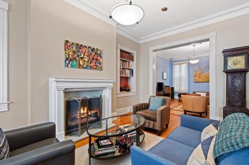 a living room with a blue couch and a fireplace at Capitol Hill Homestay Convenient to H St in Washington, D.C.