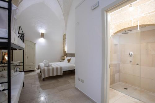 a bedroom with a bed and a bathroom with a shower at Casale Donna Rosa in Sannicola