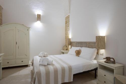 a bedroom with a white bed with towels on it at Casale Donna Rosa in Sannicola