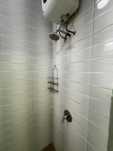 a bathroom with a shower with white tiles at Casa Rani Batu Malang Villa in Batu