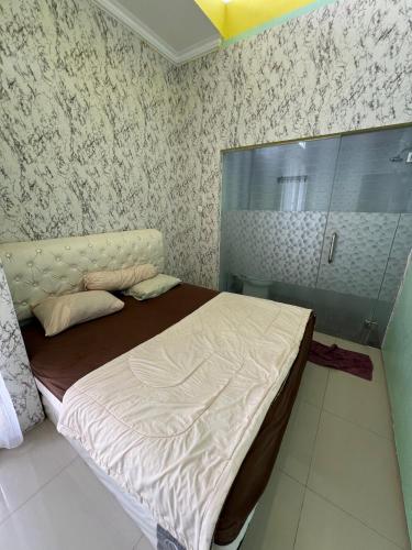 a small bedroom with a bed and a shower at Casa Rani Batu Malang Villa in Batu