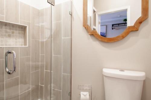 a bathroom with a shower with a toilet and a mirror at Little Penthouse in Little Italy Near Inner Harbor Studio in Baltimore