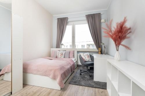 a bedroom with a pink bed and a desk at Superb Place To Live Mokotow Klobucka in Warsaw