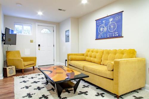 a living room with a yellow couch and a table at Stay Cozy in CoHi DC in Washington, D.C.