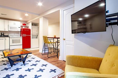 a living room with a couch and a tv on a wall at Stay Cozy in CoHi DC in Washington, D.C.