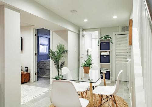 a dining room with a glass table and white chairs at Private 1-BR DC Residential-Style Stay Parking in Washington, D.C.