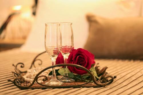 twee wijnglazen en een roos op tafel bij IRIDA COZY HOUSE στο κέντρο της πόλης in Volos