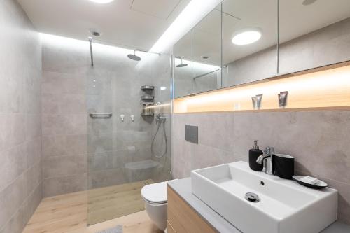a bathroom with a white sink and a shower at Apartament Superior Sea View PINEA 701 in Pobierowo