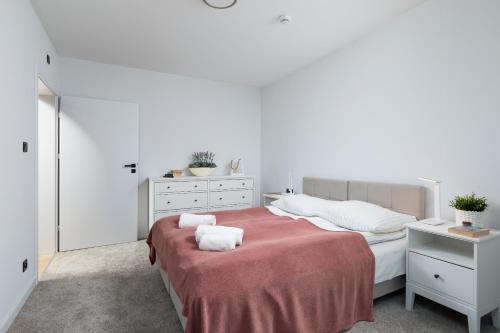 a white bedroom with a bed with towels on it at Apartament Superior Sea View PINEA 701 in Pobierowo