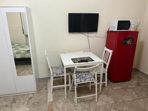 a small kitchen with a small table and a red refrigerator at Residenza Eli in Piacenza